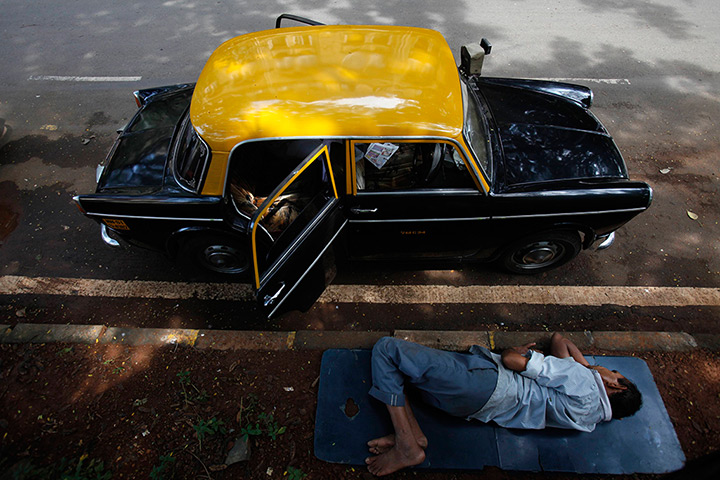 Mumbai taxis: A taxi driver takes an afternoon nap 