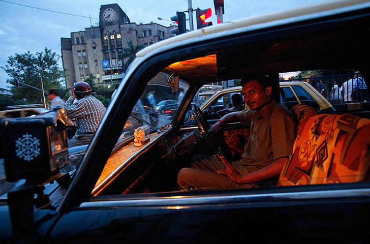 Mumbai taxis: A taxi driver waits at a signal during rush hour 