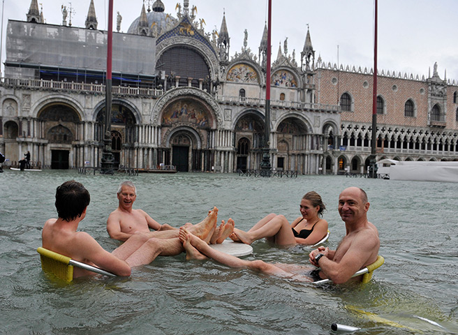 Venice floods: People sit at a table in flooded St Mark's Square 
