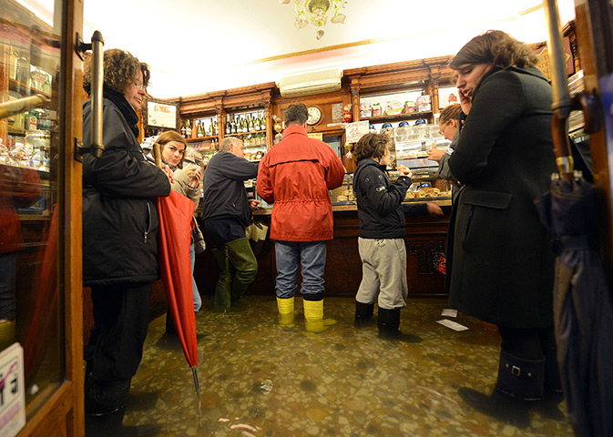 Venice floods: People take a coffee in a flooded shop