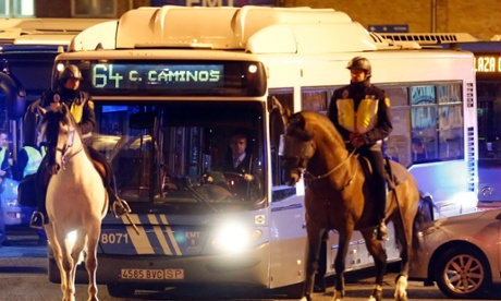 Mounted Spanish National Police officers escort a municipal bus as it leaves depots at the start of a general strike in Madrid November 14, 2012. 