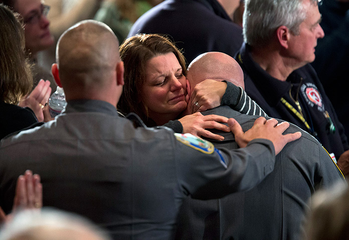 Newtown vigil: A woman embraces a policeman during a vigil 