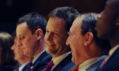 A smiling Nick Clegg sits in the audience at the Lib Dem conference