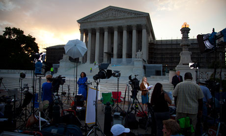 Journalists wait outside the Supreme Court for a landmark decision on health care 
