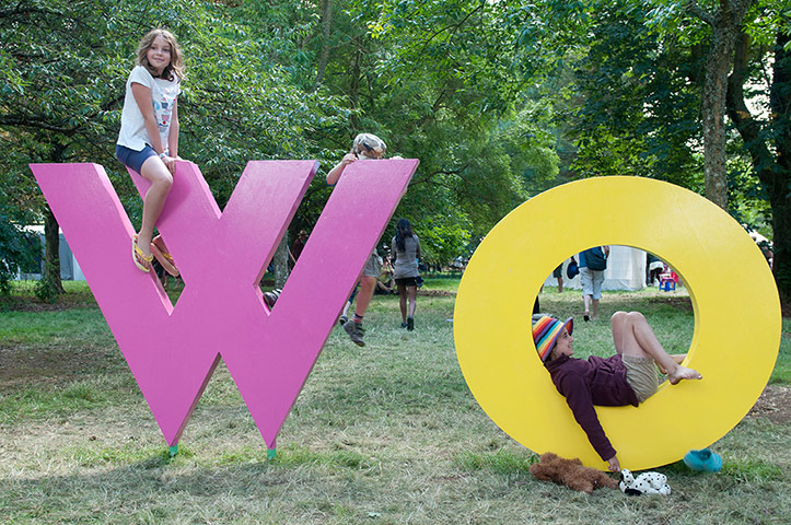 Womad atmosphere: Kids climb on the Womad sign in the arboretum