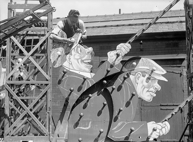 Blackpool illuminations: 1936:  A workman fitting light bulbs onto an elaborate model