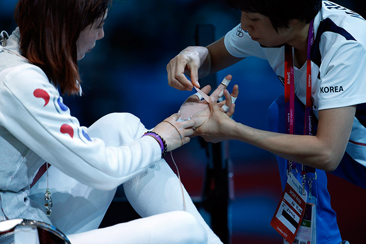 Olympic pain: Korea's Jeon Hee Sook has a hand injury attended to in the fencing