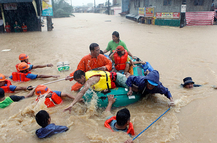 Floods in Manila: Rescuers pull a rubber boat 