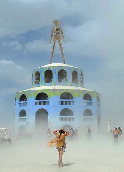 Burning Man: A woman walks toward the Man on a dusty afternoon at Burning Man festival