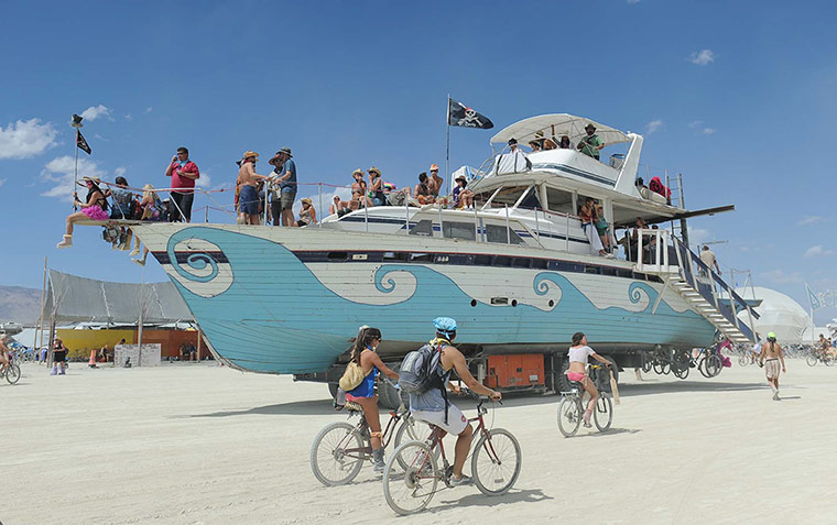 Burning Man: An old wooden yacht art car rolls through the playa at Burning Man