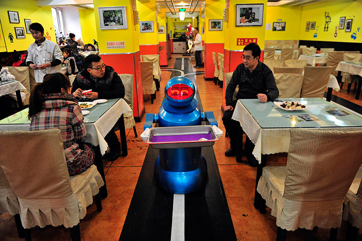 Robot Restaurant: A 'waiter' robot holds an empty tray after serving meals to the customers 