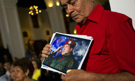 A supporter of Chavez holds a picture of him