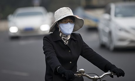 A woman wearing a face mask cycles in Beijing
