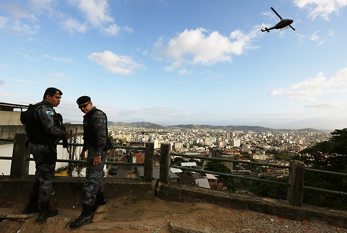 Favela clearance: Special forces soldiers stand by as a military helicopter flies overhead  d