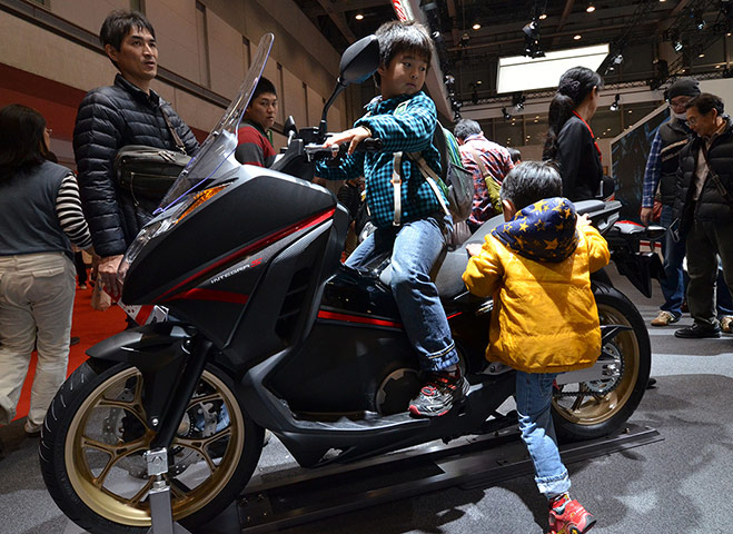 L.A. and Tokyo Motor Show: Little boys try to ride Japanese auto giant Honda Motor's motorcycle 