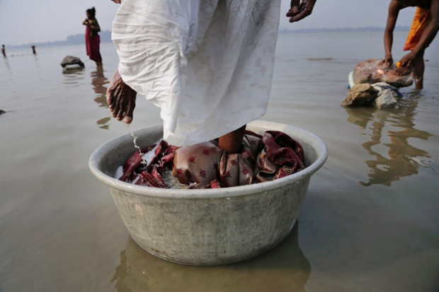 An Indian dhobi washes clothes in the Brahmaputra River in Gauhati, India.