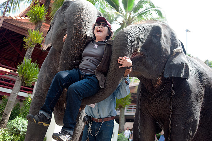 Chinese tourists: A woman is lifted by two elephants