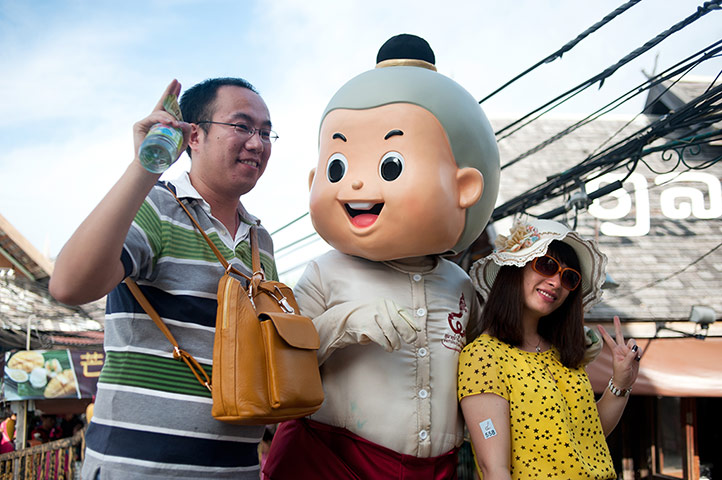 Chinese tourists: Chinese tourists pose with a mascot