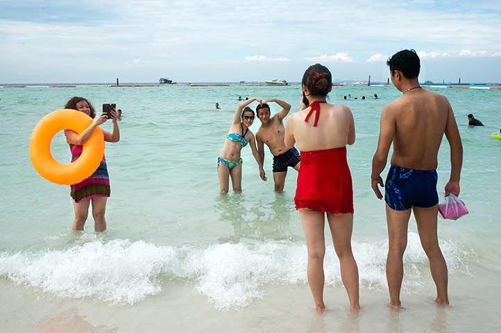 Chinese tourists: Honeymooners pose for pictures on Tawaen Beach