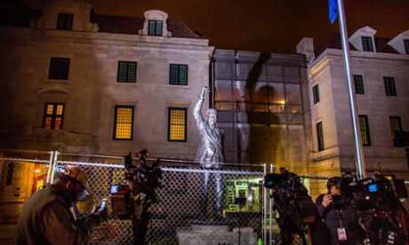 Members of the media gather around a statue of the late former South African President Nelson Mandela, which is illuminated behind a construction fence, outside the South African Embassy in Washington DC, USA, 05 December 2013.