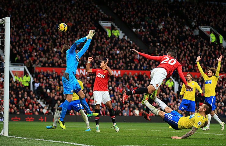 Premiership Saturday: Robin van Persie of Manchester United heads over goalkeeper Tim Krul of New