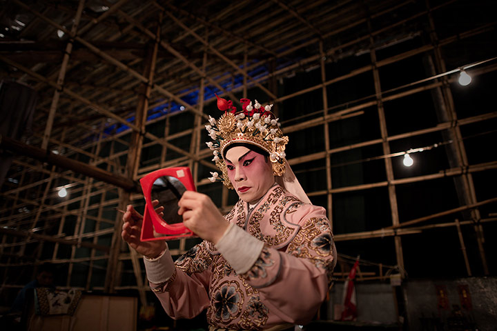 Cantonese opera: An actor applies makeup backstage in the Bamboo Theatre