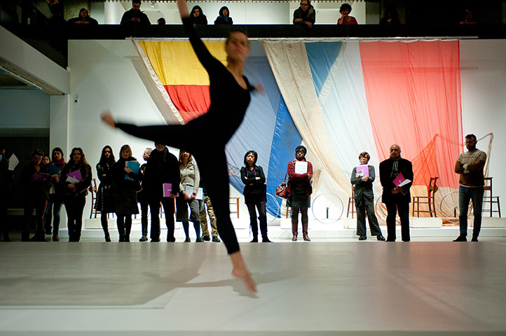 Barbican: A dancer leaps infront of visitors and artworks in the Barbican