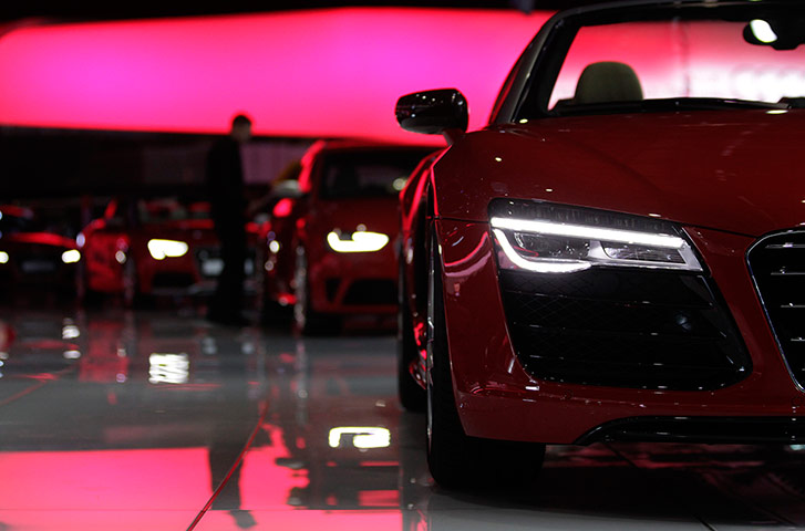 Geneva motor show: A staff cleans cars on the Audi stand 