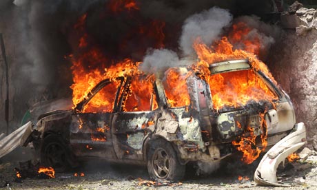 A car goes up in flames near the scene of a blast in Mogadishu