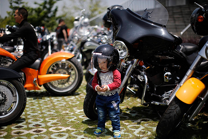 Harley rally: A little boy wearing a helmet poses at the rally