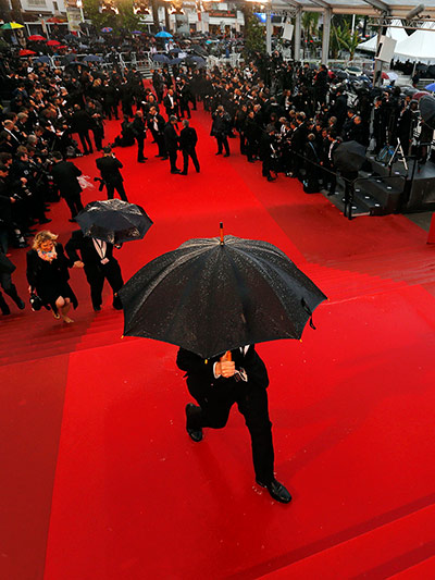Man carrying umbrella red carpet