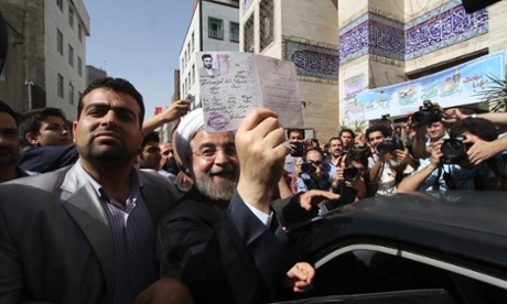 Hassan Rouhani shows his identity papers after casting his ballot in Tehran.