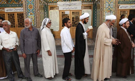 Men stand in line to vote during the Iranian presidential election at a mosque in Qom, 120 km (74.6 miles) south of Tehran.