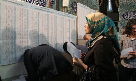 A woman looks at a board at a polling station in Tehran.