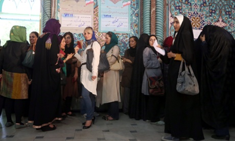 Iranian women wait in line to cast their vot at a polling station during the Iranian presidential elections in Tehran.