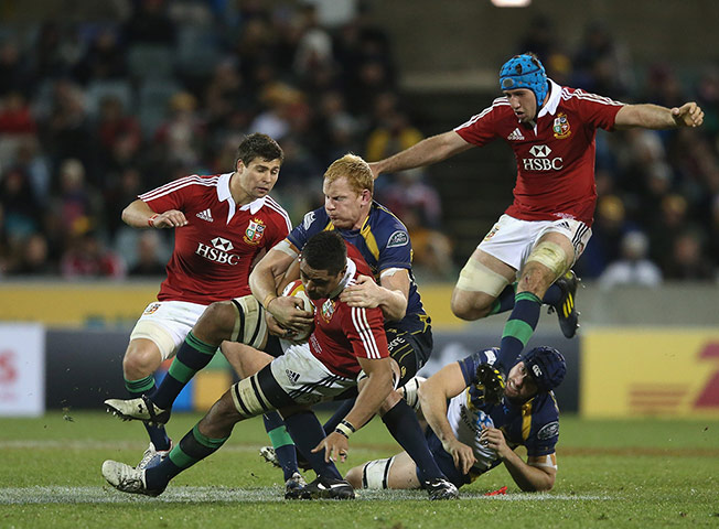 Lions: Toby Faletau of the Lions is tackled by Peter Kimlin 
