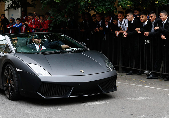 Supercar parade: School children watch as Ujjol Hussain, 16, is driven past in a hired Lambo