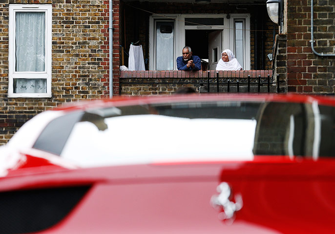 Supercar parade: Residents look at a Ferrari from their balcony