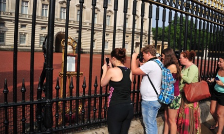 Tourists take pictures of the easel announcing the royal birth.