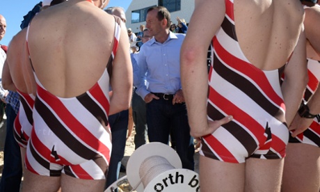 Opposition leader Tony Abbott speaks with beach lifesavers after finishing in the City2Surf fun run at Bondi Beach in Sydney, Australia, 11 August 2013.