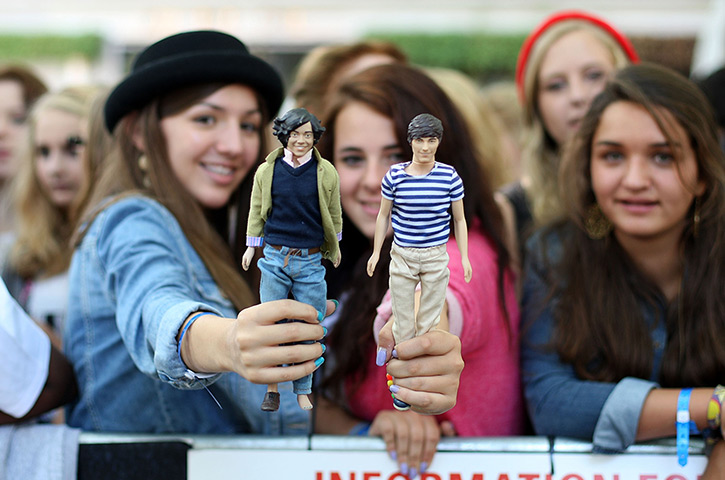 One Direction fans: Fans hold dolls of band members Harry Styles and Louis Tomlinson
