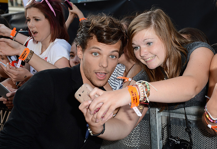 One Direction fans: Louis Tomlinson from One Direction poses with fans 