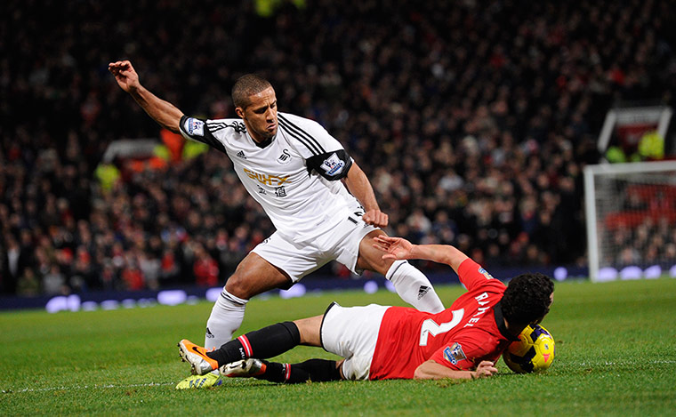 United versus Swansea: Rafael da Silva comes off second best in this challenge by Wayne Routledge
