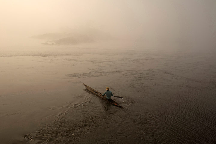 20 Photos: A fisherman paddles his boat on the river Oubangui in Bangui