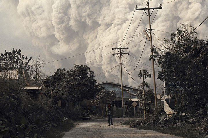 20 Photos: A villager walks as Mount Sinabung erupts in Beras Tepu