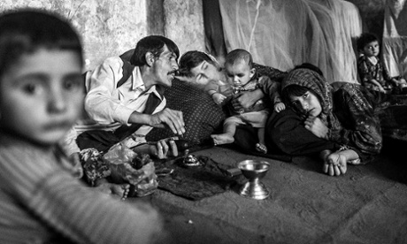 A man gives his children their daily ration of opium, in the north of the country