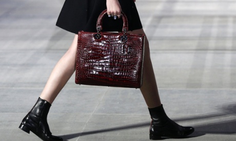 model carries snakeskin-effect bag on the catwalk in Tokyo