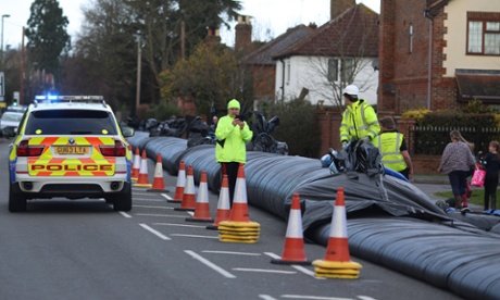 Workers install an aqua dam to protect homes from expected floodwater in Chertsey, Surrey.