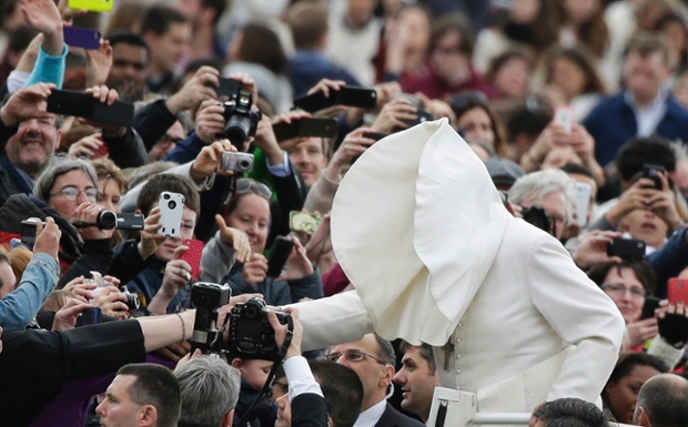 A gust of wind blows Pope Francis's mantle as he arrives to lead his Wednesday general audience in St Peter's square at the Vatican.