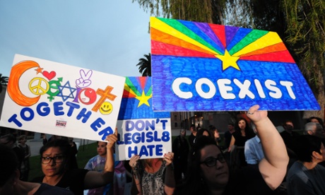 Demonstrators rally in Phoenix on Wednesdav to pressure Jan Brewer to veto the anti-gay rights bill.